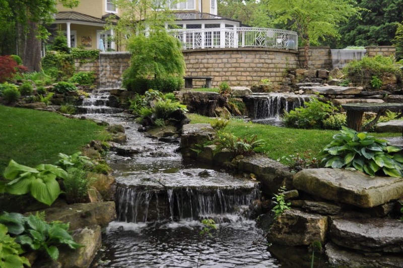 paysagiste-SERANON-min_landscaping-rock-louisville-ky-traditional-landscape-and-boulders-brick-wall-bushes-grass-koi-law